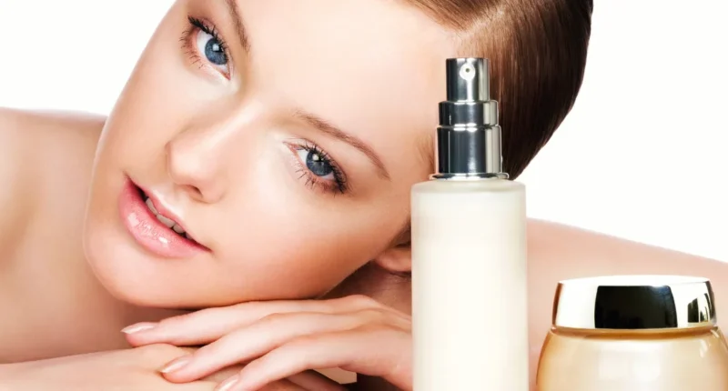 Woman with skincare products: "Close-up of a woman with clear skin lying down next to a spray bottle and a cream jar, representing luxury skincare and beauty routine."