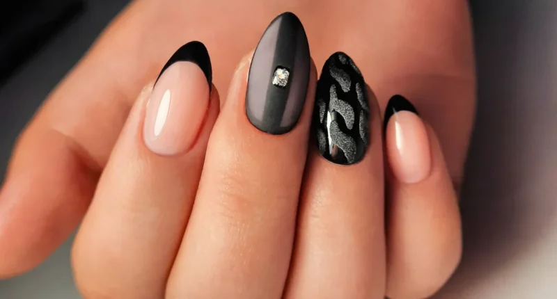Smooth black nails with silver swirl accents, reminiscent of soft velvet and delicate silver jewelry, perfect for a touch of everyday luxury.